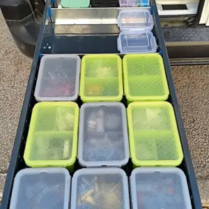 Asiakkaat asentamassa pitkiä vetolaatikoita pakettiautoon ja esittelemässä järjestystä