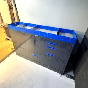 Ford Transit L3 -retkeilyauton vasemmalle sivuseinälle asennettu 152 cm leveä hyllykkö, jonka vetolaatikot avautuvat takaovista ulos.